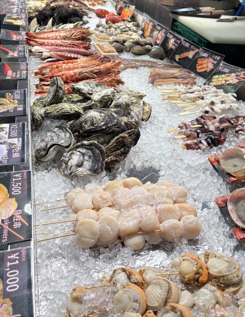 Fresh seafood displayed at Kuromon Ichiba Market in Osaka, including fish, shellfish, and crustaceans
