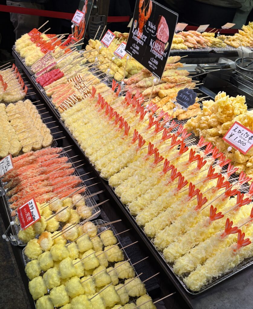 Close-up of a fake seafood food display at Kyoto’s Nishiki Market, featuring realistic plastic models of fish and shellfish in a storefront