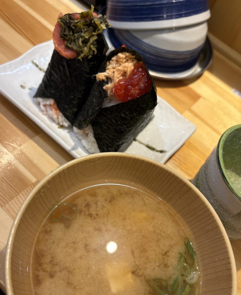 A tray with handmade onigiri rice balls and a bowl of miso soup served at the popular Onigiri Goroichan spot in Osaka.