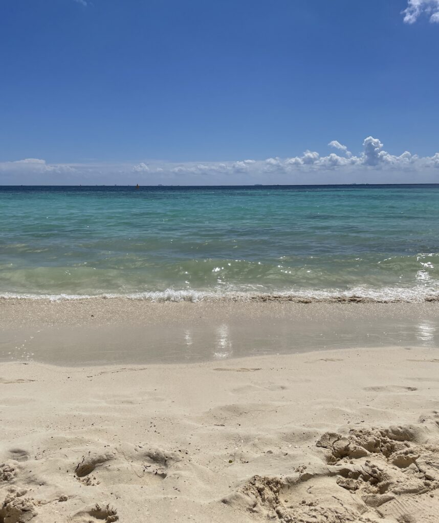 Crystal clear turquoise water and bright blue skies on a sunny day at Playa del Carmen’s main beach, a perfect tropical scene.
