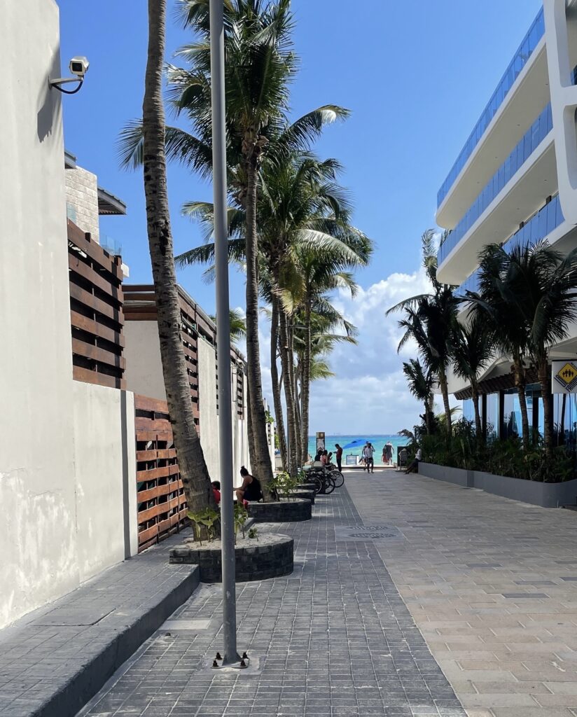 Clear pedestrian pathway in Playa del Carmen on a beautiful sunny day with the turquoise sea visible in the distance.
