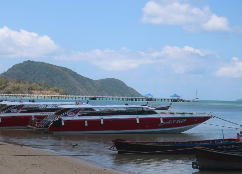 Boats docked along the sandy shoreline of Rawai Beach in Phuket, Thailand
