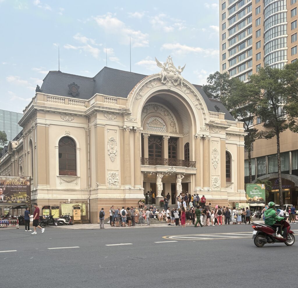 Front view of the Saigon Opera House on a sunny day with its elegant French colonial architecture
