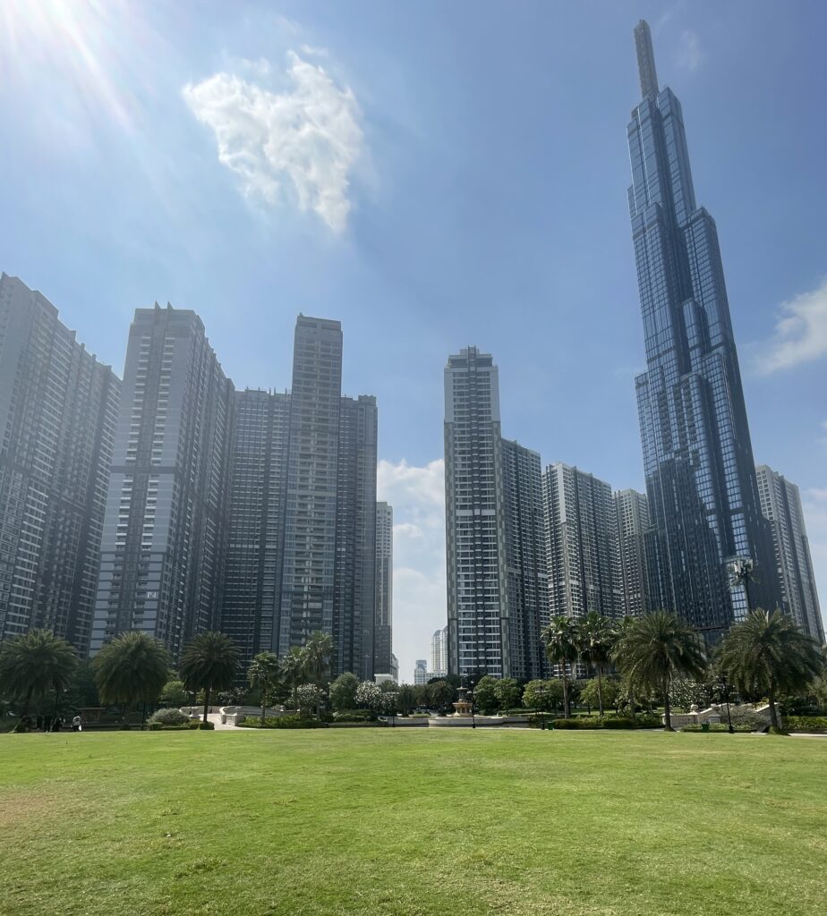 Spacious park in Ho Chi Minh City with skyline view of Landmark 81 and surrounding skyscrapers on a sunny day
