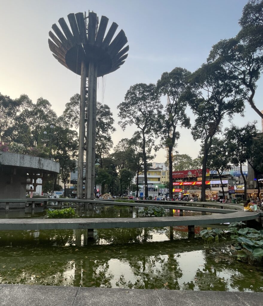 Turtle Lake in Saigon during the evening, with soft lighting, calm waters, and locals gathering around