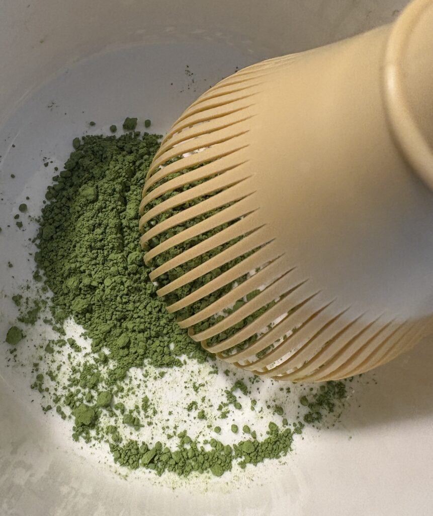Traditional matcha being whisked in Uji, Kyoto with chasen and ceramic bowl during tea preparation