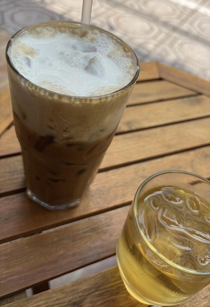 Vietnamese iced coffee and Jada tea served street-side in Ho Chi Minh City, placed on a small table with city life in the background
