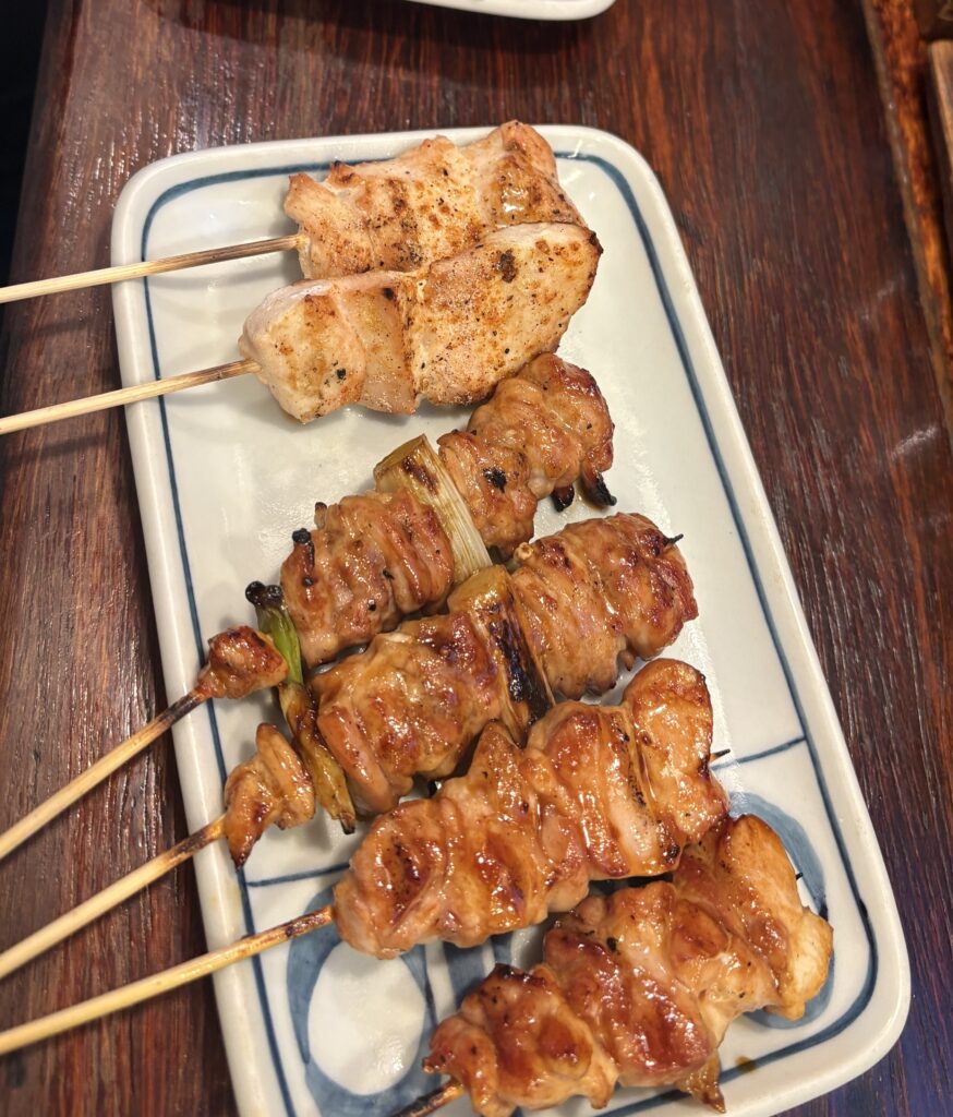 Freshly grilled yakitori skewers served on a plate at a local Kyoto eatery.