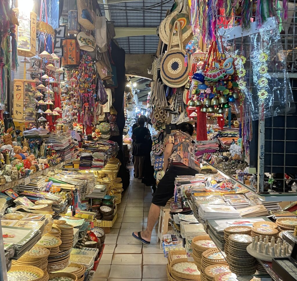 Inside Ben Thanh Market in Ho Chi Minh City with stalls displaying goods, a common spot for tourist scams in Vietnam