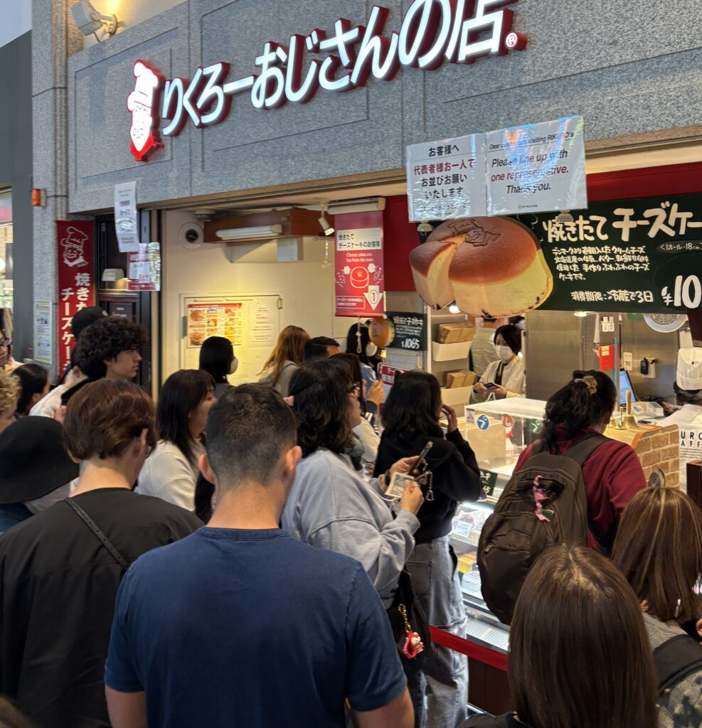 Long line of people waiting outside a famous cheesecake shop in Osaka, Japan.