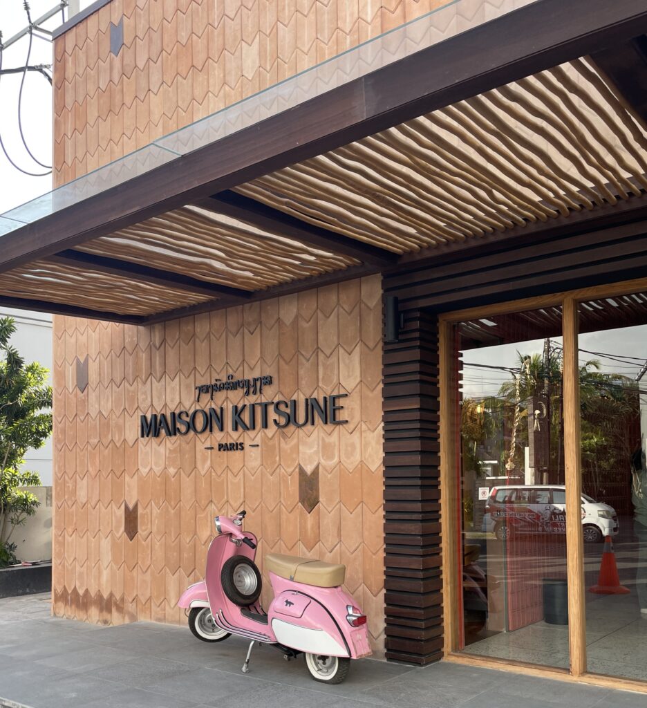 Outside of Desa Kitsuné luxury store in Canggu, Bali with stylish storefront and a pink scooter parked in front