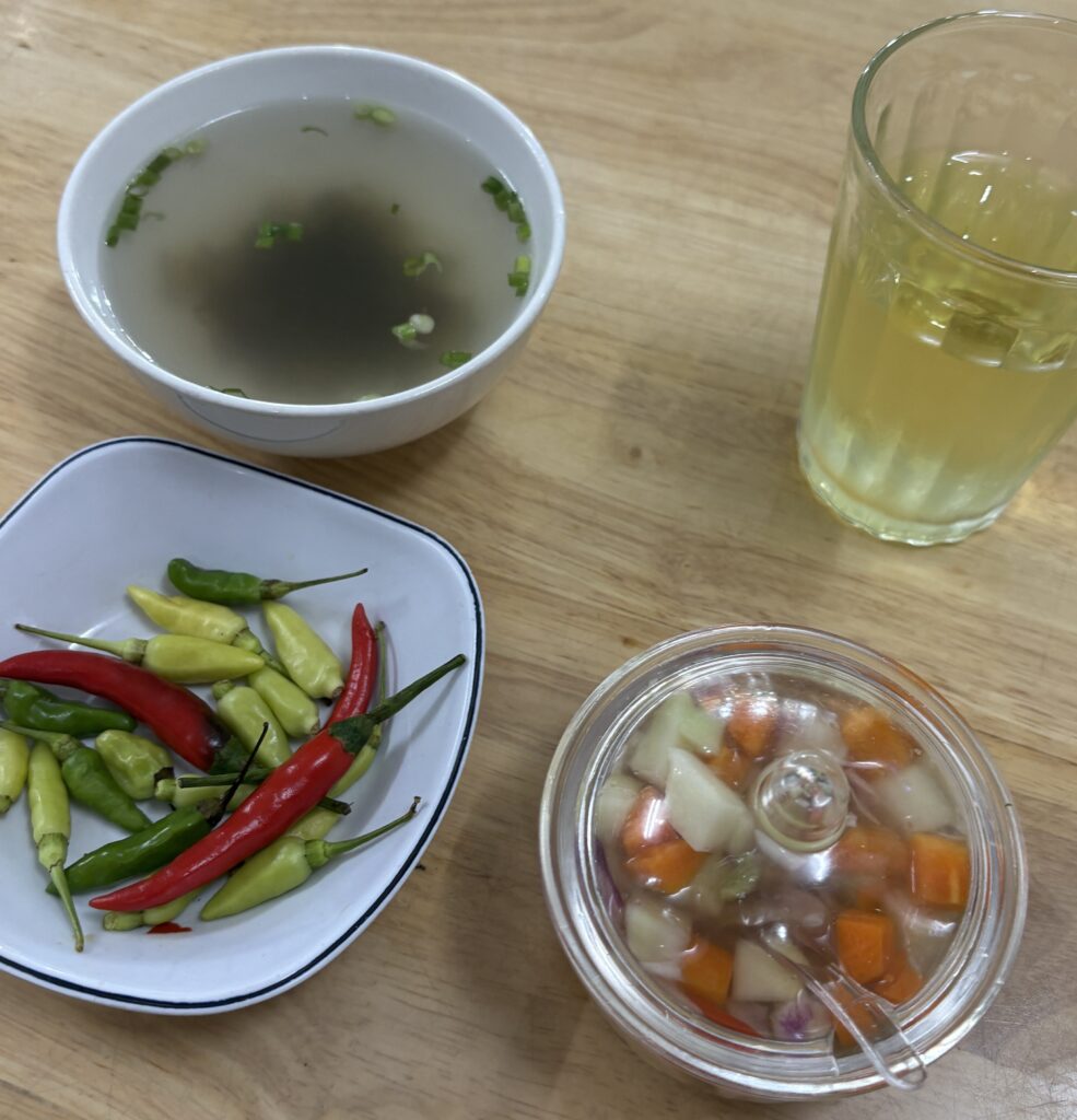 Fresh red chillis served with broth and iced tea in Vietnam
