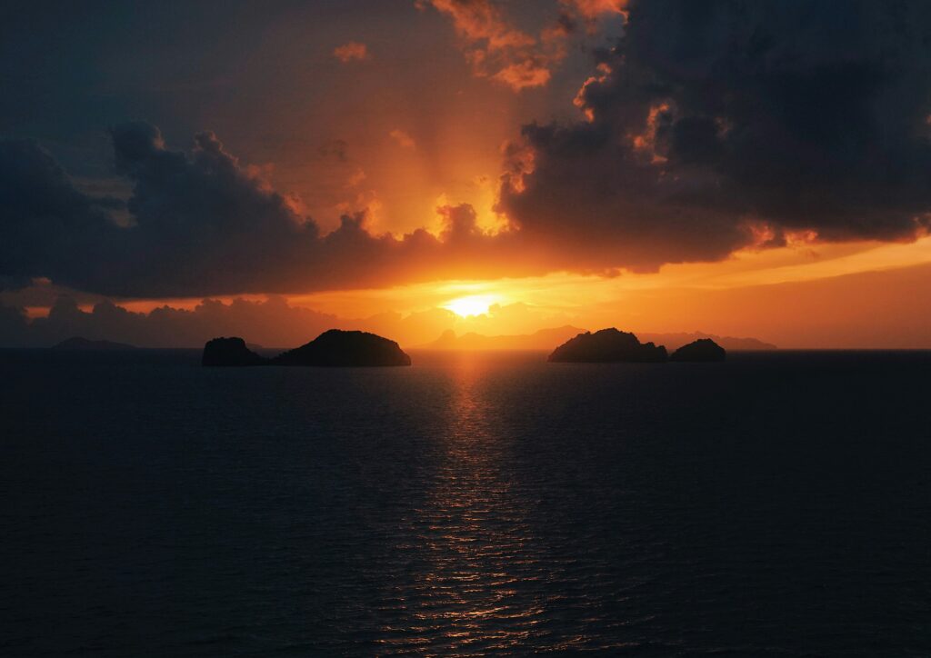 Vibrant sunset over the ocean in Koh Samui with golden reflections on the water