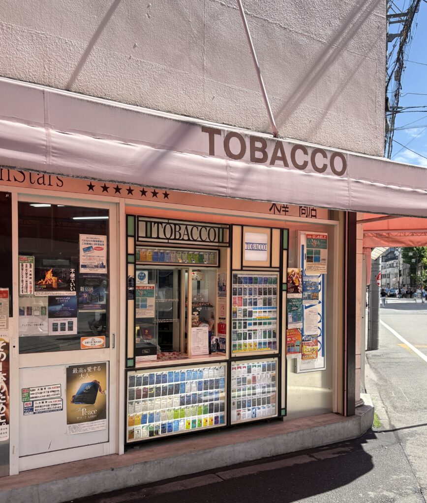 Unique pink-themed retro tobacco shop in Osaka with a counter selling various tobacco products