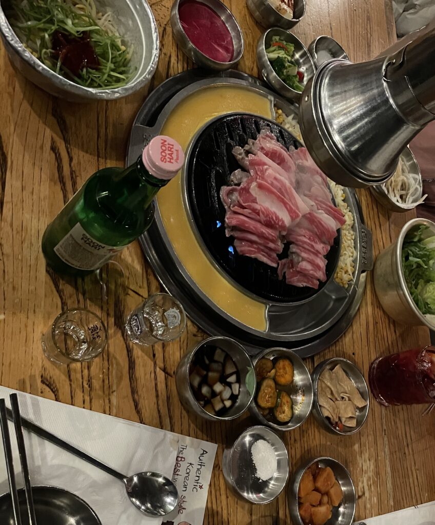 Full table spread of Korean BBQ dishes at Baekjeong NYC in Koreatown