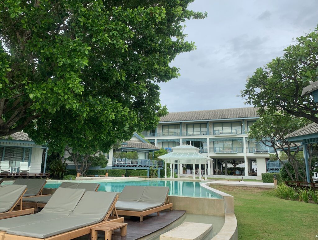 Beachfront resort in Cha-Am, Thailand with pool and loungers facing the sea
