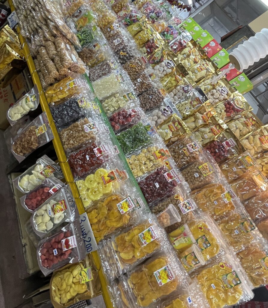 Several varieties of dried fruits, including mango, coconut, and more, displayed at a market in Chiang Mai, Thailand.