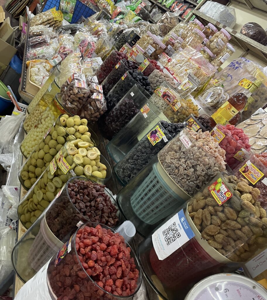 Close-up of massive amounts of dried fruits, including mango and coconut, at Warorot Market in Chiang Mai.