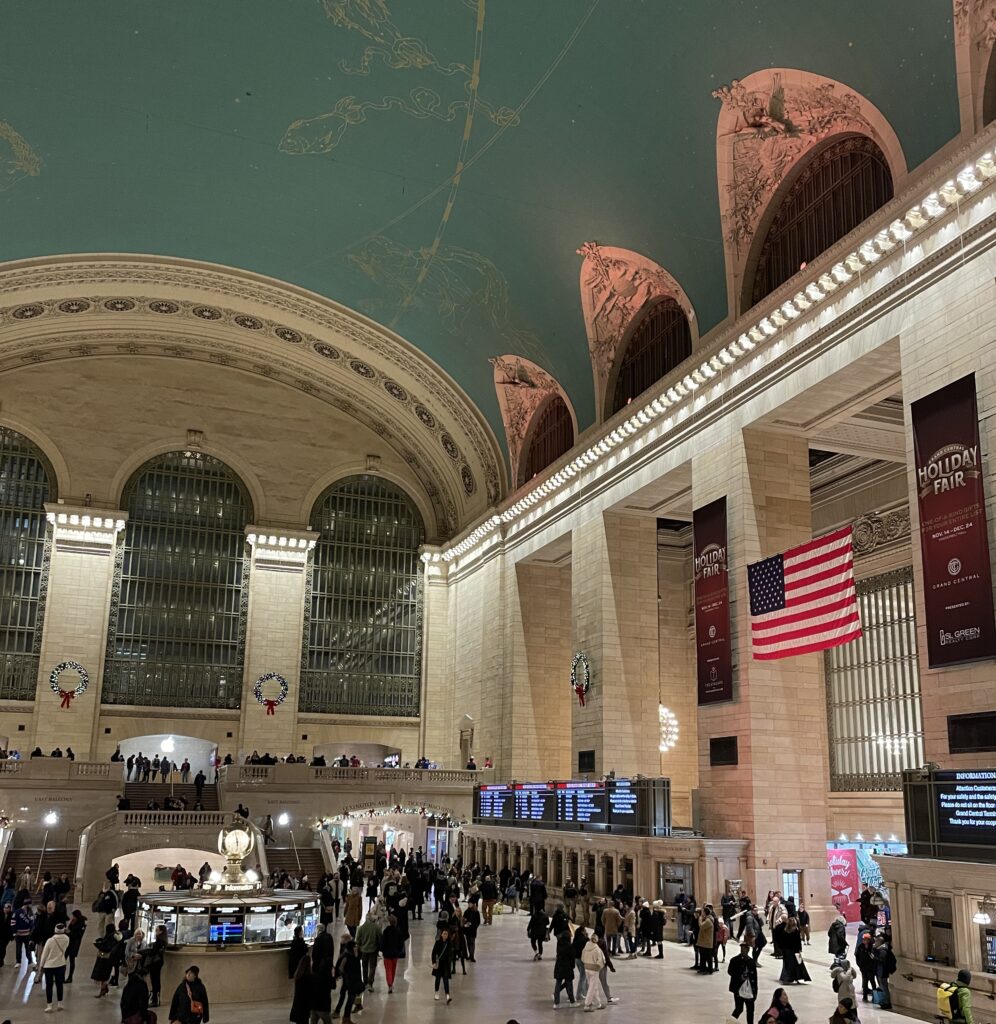Inside Grand Central Terminal in New York City, showcasing the iconic celestial ceiling and busy commuters.