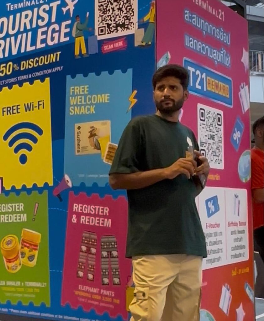 Indian man attempting honey and herbal remedy scam outside Terminal 21 shopping mall in Bangkok, Thailand
