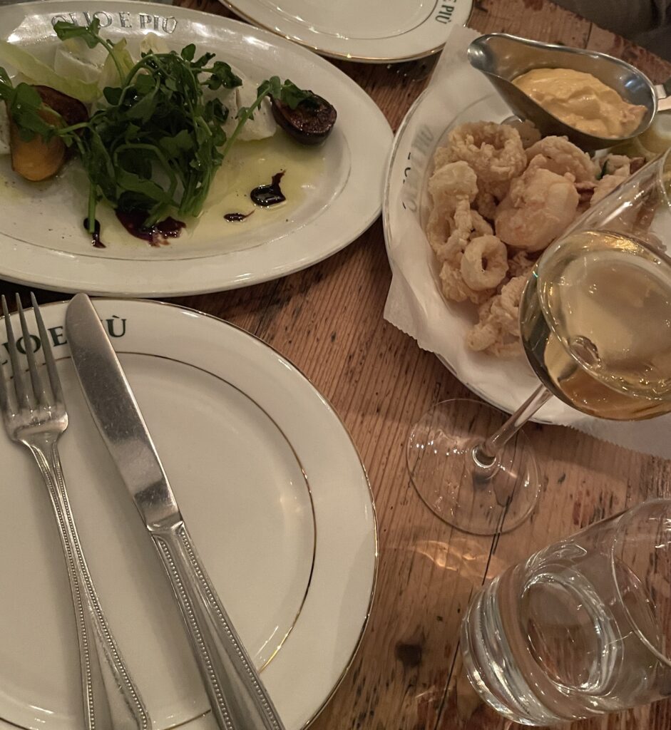 Glass of wine and plate of calamari at an upscale Italian restaurant in NYC