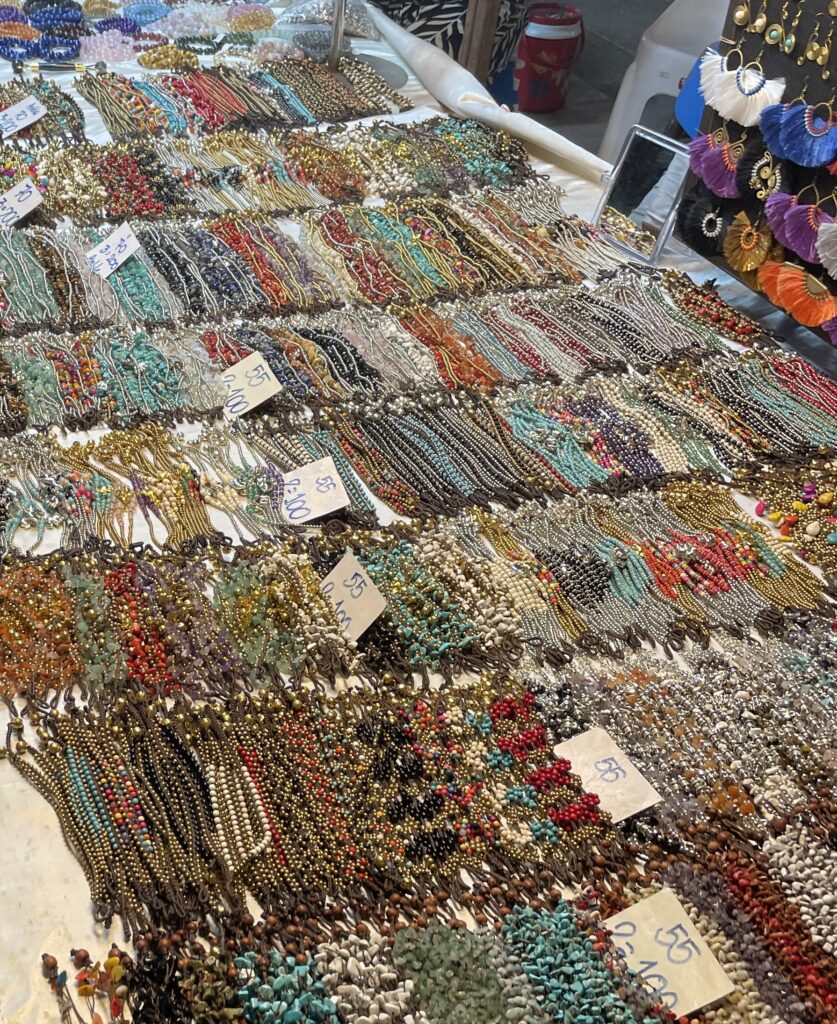 A wide array of jewelry being sold at the Chiang Mai Sunday Night Market, with rings, necklaces, and bracelets on display.
