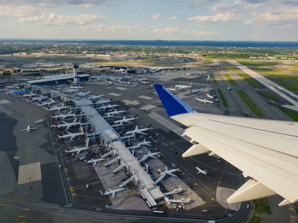 Aerial view of JFK Airport with terminals and multiple planes on the tarmac