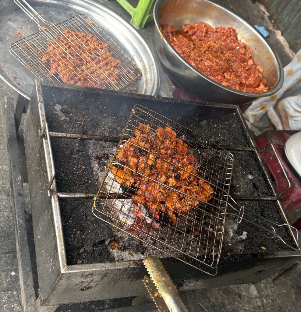 Pork being grilled on the streets of Da Nang, prepared fresh for bánh mì sandwiches.