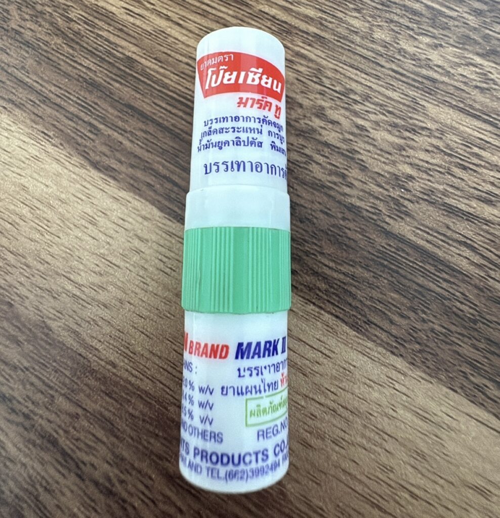 Close-up of a Poy-Sian herbal inhaler, a popular and affordable Thai remedy found in 7-Elevens, pharmacies, and markets.
