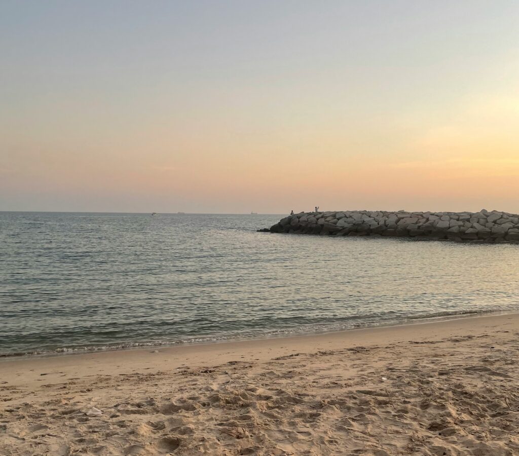 Quiet empty beach at sunset in Rayong, Thailand with calm waves and golden light
