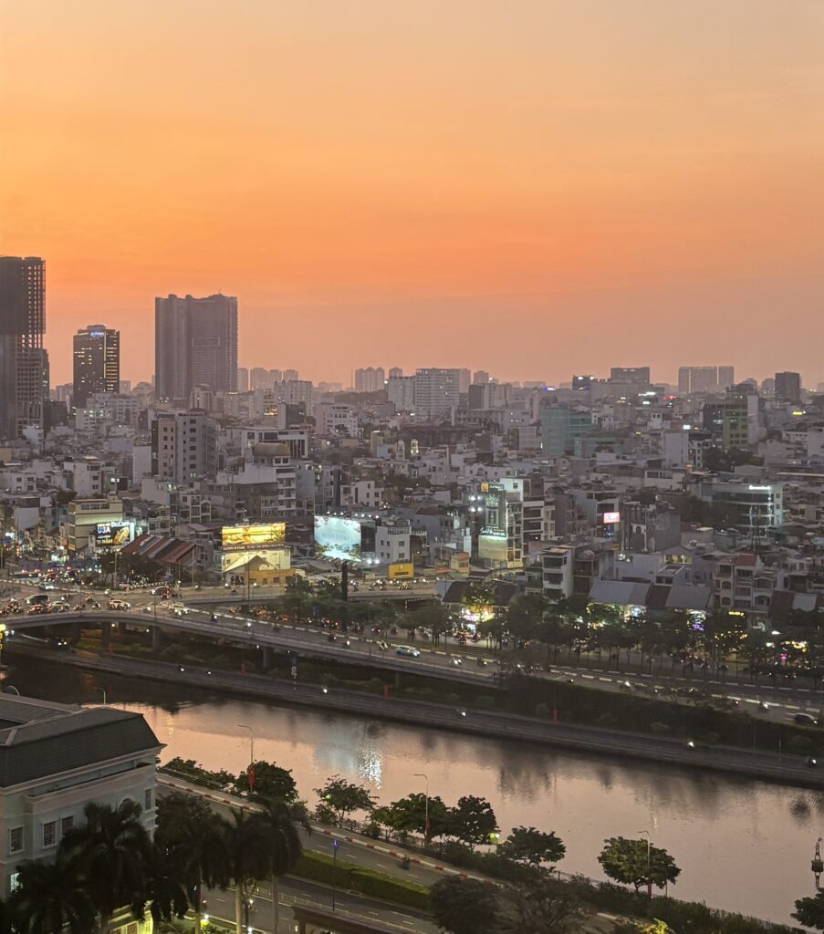 Sunset view of Saigon with the river and city skyline seen from a hotel rooftop in Vietnam
