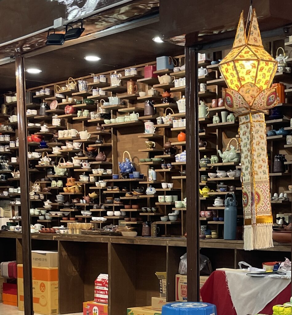 Many Thai tea sets and coffee mugs displayed for sale at the Chiang Mai night market, a popular spot for unique souvenirs.

