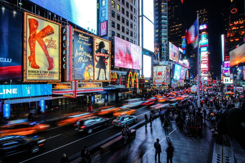 Times Square at night in New York City with bright billboards glowing above the crowded streets.