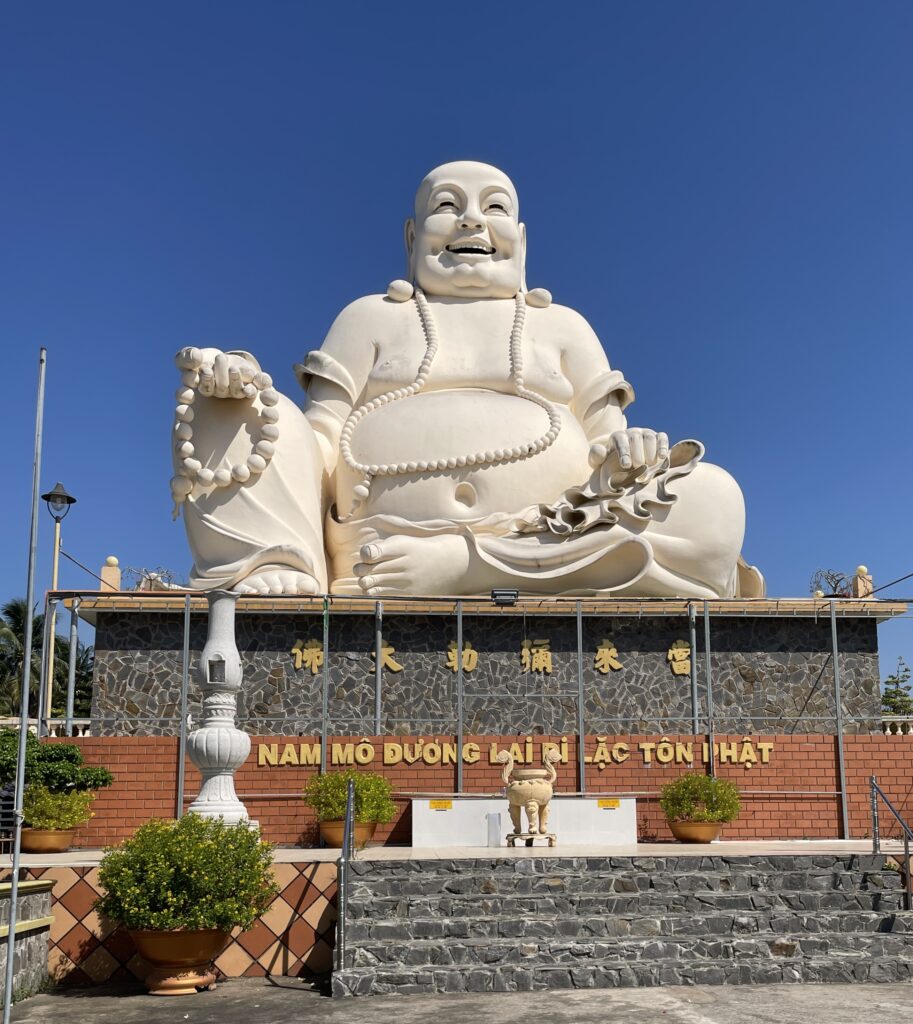 Laughing Buddha statue at Vinh Trang Pagoda in My Tho, Mekong Delta, Vietnam