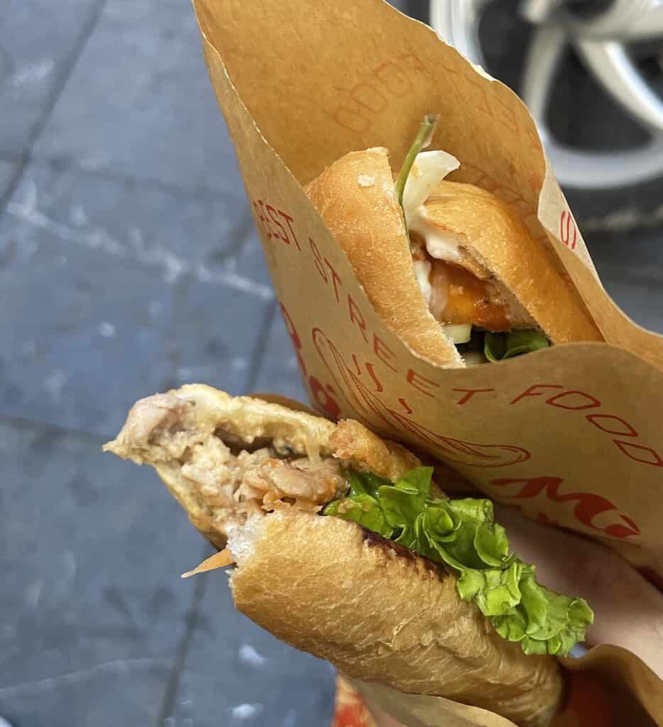 Two banh mi sandwiches from Banh Mi Mama in Hanoi, filled with chicken, fresh lettuce, and vegetables.