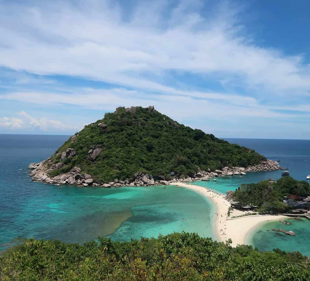 Viewpoint overlooking Koh Tao and Koh Nang Yuan on a clear, sunny day with vivid blue waters and lush greenery.
