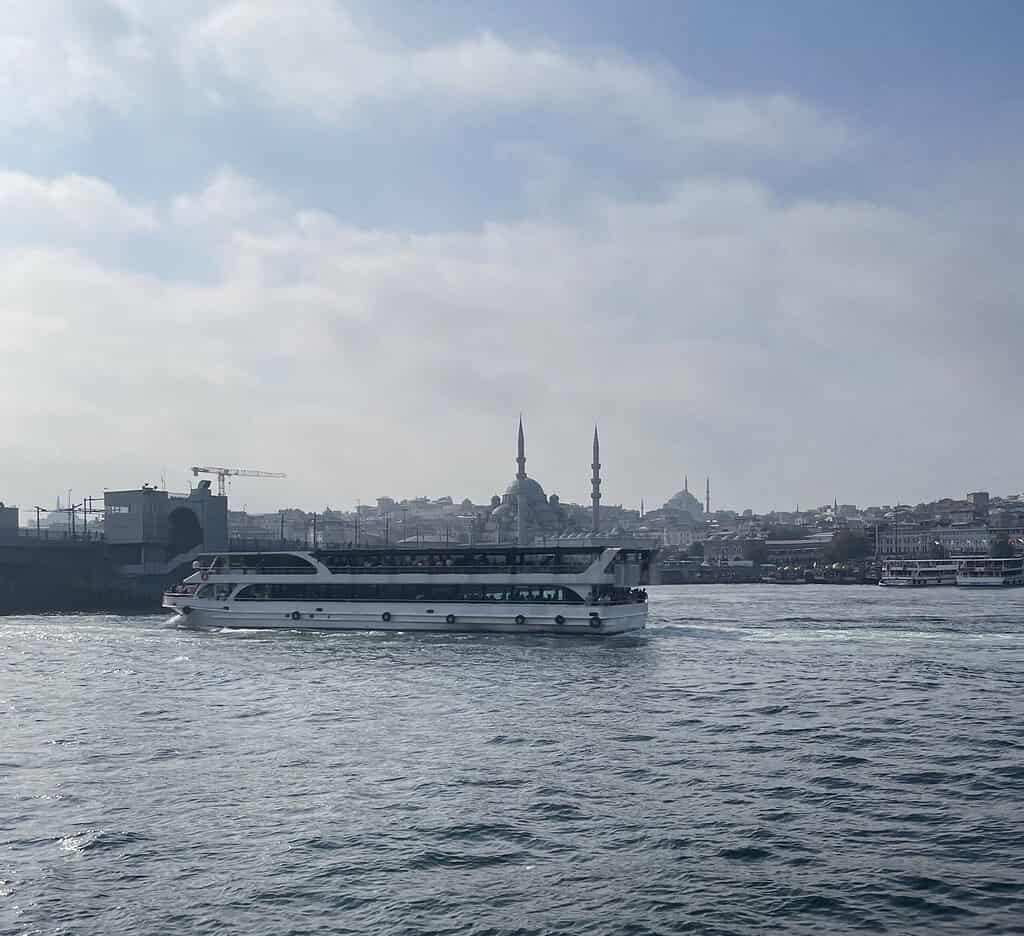 A large ferry crossing the Bosphorus in Istanbul during the daytime with city views in the background.