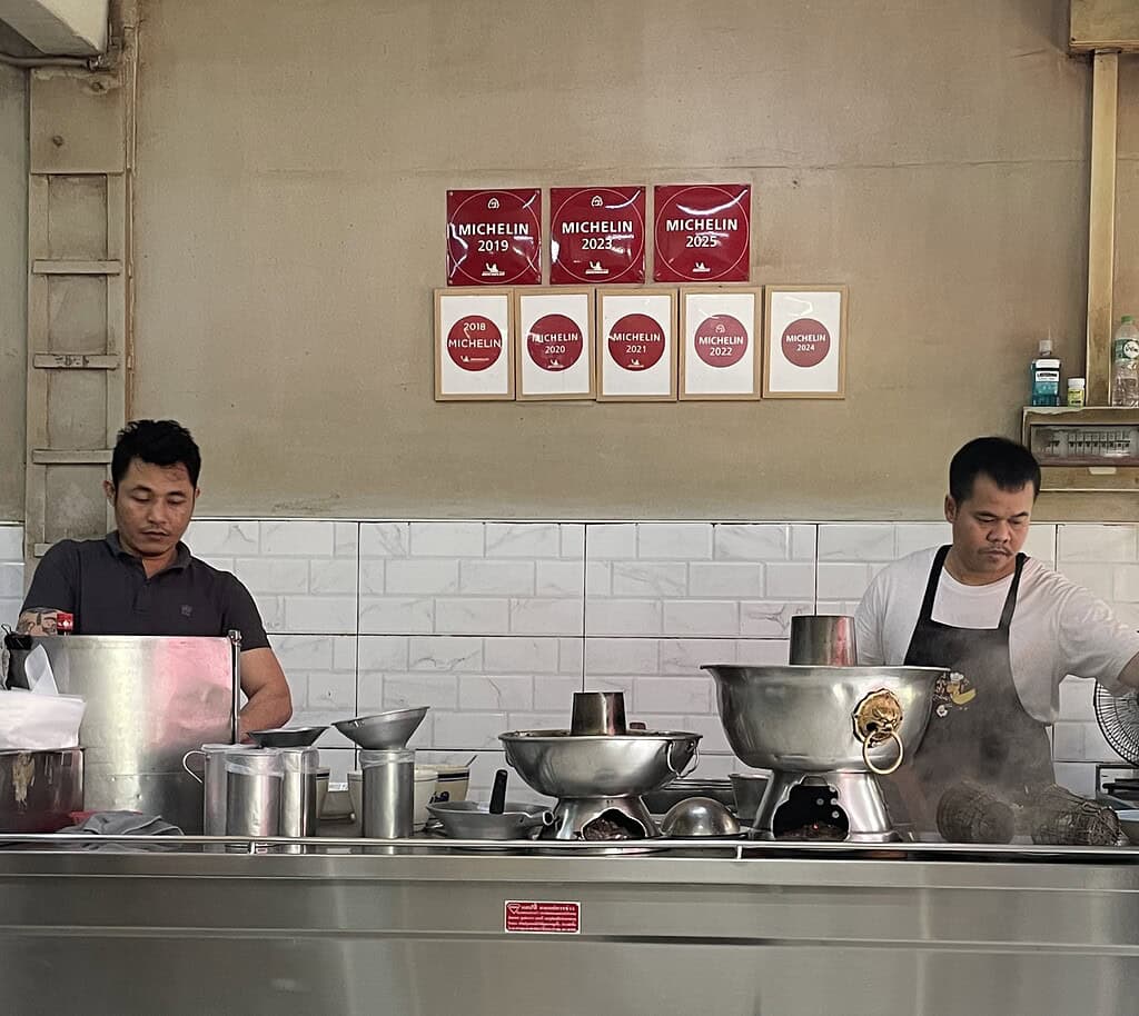 Two men preparing food inside Tang Sui Heng, a well-known Michelin multi-star Chinese restaurant in Bangkok.
