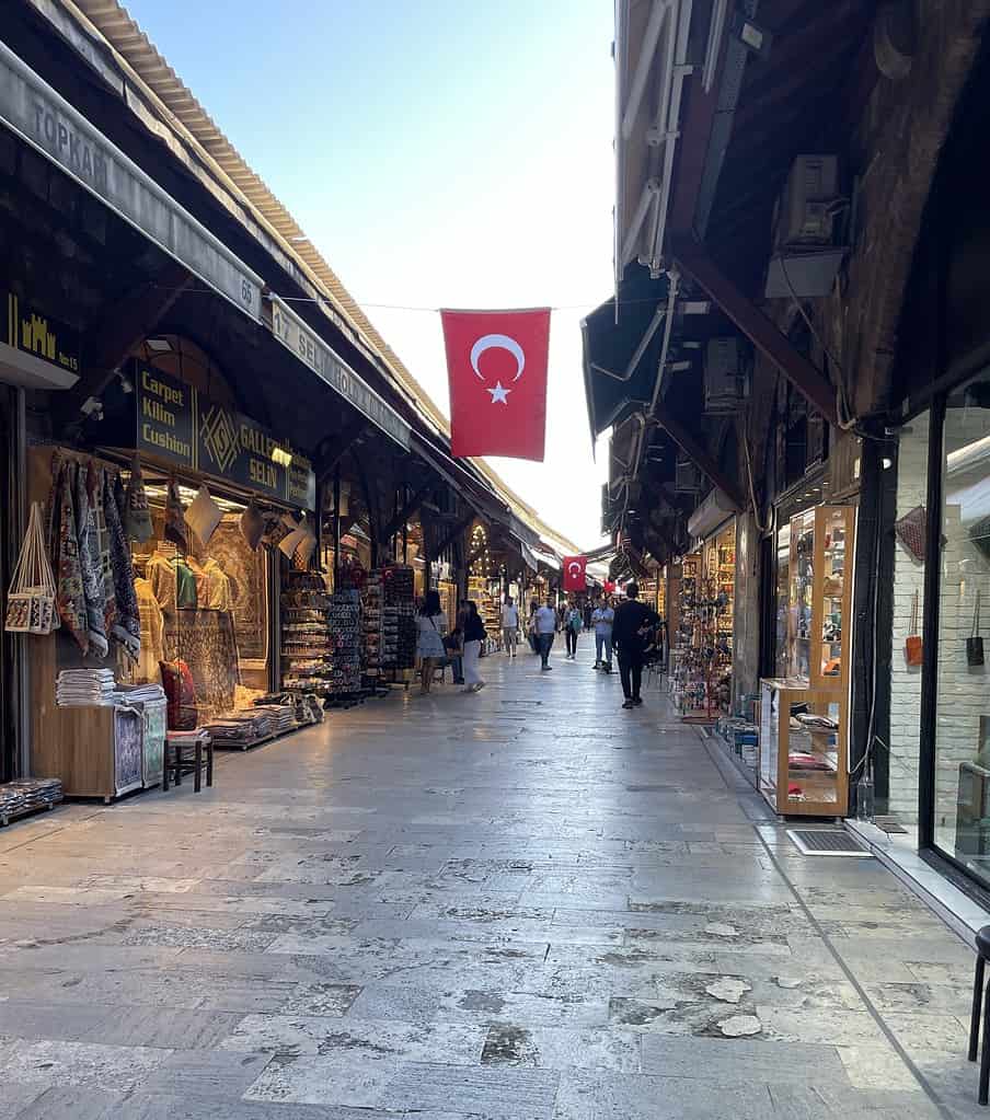 Turkiye flag hanging above a narrow street lined with shops on both sides in the bustling Sirkeci area of Istanbul.